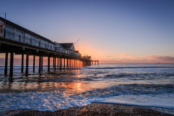 UK, Suffolk, Southwold Long exposure shot from the beach of Southwold Pier, with the Sun breaking through the clouds.