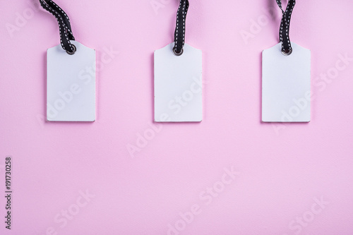 empty white tags in a row on pink background top view mock up
