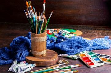 Paints for drawing and brush on a background in a composition