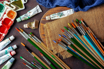 Paints for drawing and brush on a background in a composition