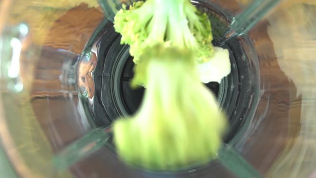 Fresh broccoli pouring in blender, close-up video
