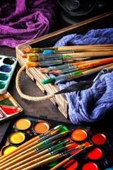 Paints for drawing and brush on a background in a composition