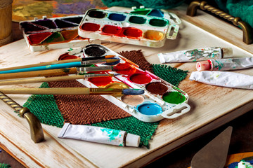 Paints for drawing and brush on a background in a composition
