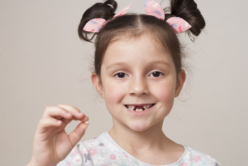 little girl and a milk tooth