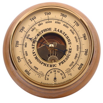 Old yellow-brown aneroid barometer in wooden body on a white