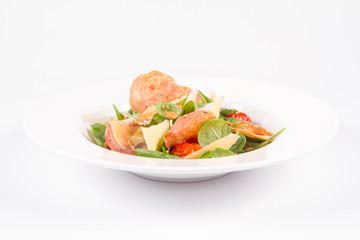 Baby spinach, dry sausage, matured cheese, roast tomatoes, thyme-balsamic vinaigrette salad on a white background