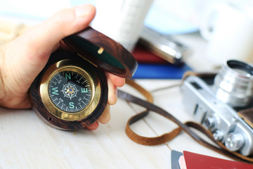 Compass in hand, from a tourist on the background of vintage camera