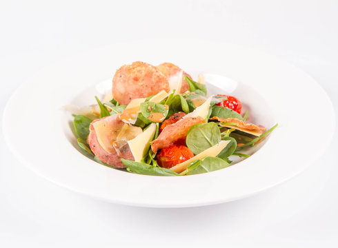Baby spinach, dry sausage, matured cheese, roast tomatoes, thyme-balsamic vinaigrette salad on a white background