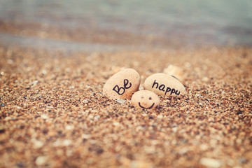 Beautyful sunlight with clean sea sand and the waves are blowing on the beach. Small rocks with inscription, near the water.