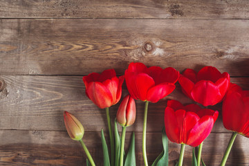 Naklejka na ściany i meble Row of tulips on wooden background with space for message. Mother's Day background.