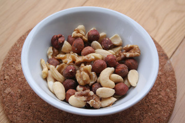 Mixed nuts in a bowl on wooden background
