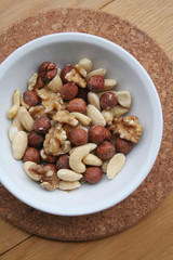 Mixed nuts in a bowl on wooden background
