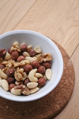 Mixed nuts in a bowl on wooden background
