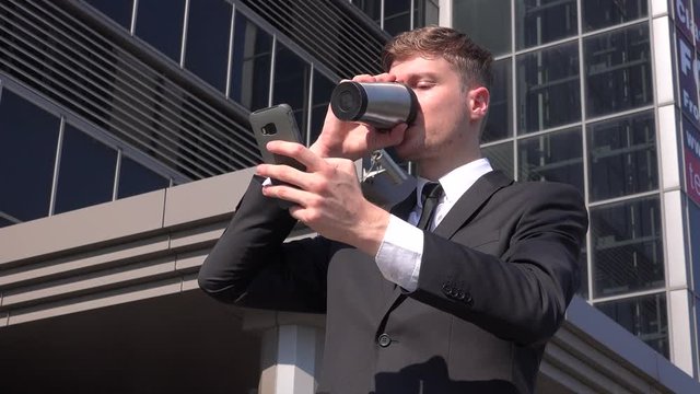 Stylish entrepreneur business person outside drinking morning coffee using phone