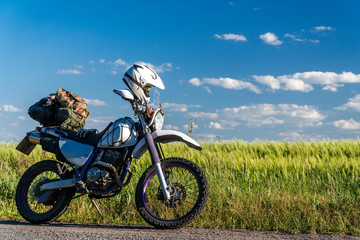 Fototapeta na wymiar off road dual sport enduro motorcycle on the road between rice fields at sunset, travel concept design