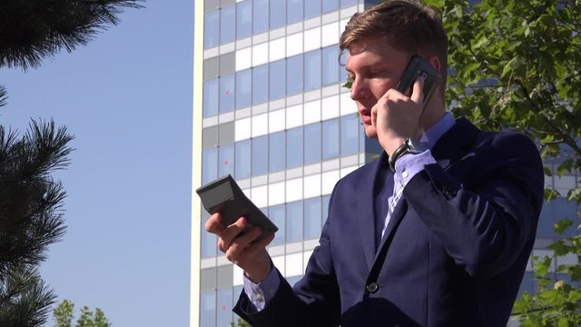 Leader salesman outside office entrepreneur with pocket calculator phone calling