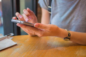 A girl is sitting with a phone in a cafe, a coffee house