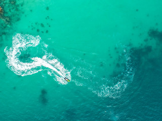 People are playing a jet ski in the sea.Aerial view. Top view.amazing nature background.The color of the water and beautifully bright. Fresh freedom. Adventure day.clear turquoise at tropical beach