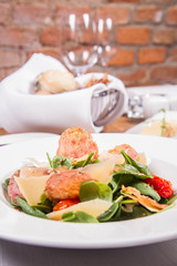 Baby spinach, dry sausage, matured cheese, roast tomatoes, thyme-balsamic vinaigrette salad served in a restaurant