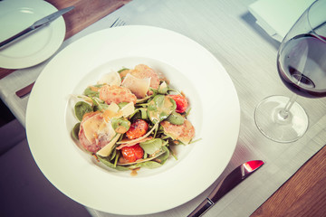 Baby spinach, dry sausage, matured cheese, roast tomatoes, thyme-balsamic vinaigrette salad served in a restaurant