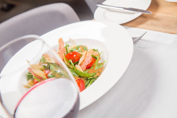 Baby spinach, dry sausage, matured cheese, roast tomatoes, thyme-balsamic vinaigrette salad served in a restaurant