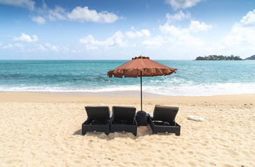 Image of blue ocean horizon of tropical sandy beach with sunbed and sun umbrella
