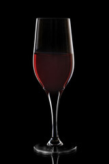 Transparent wine glass with red wine on black background, elegant image for use in design