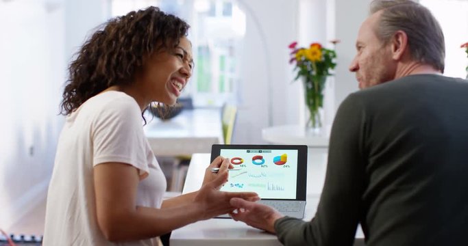 4K Business partners looking at financial data on computer & discussing company growth. Slow motion.