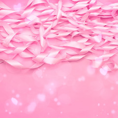 A coil of decorative satin ribbons of pink color.