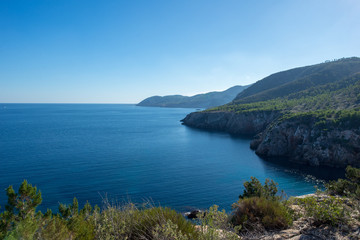 The cove will be with blue water on the island of Ibiza