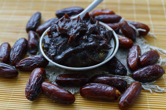 Sweet tasty dates together with date honey on the table