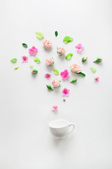 Fototapeta na wymiar Spring flowers - roses and violets - bursting out espreso cup
