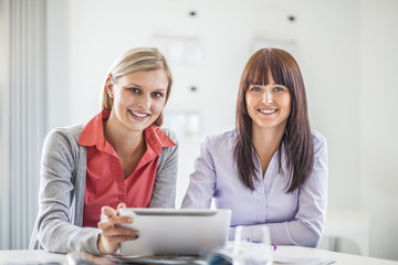 Portrait of young businesswomen using digital tablet in office