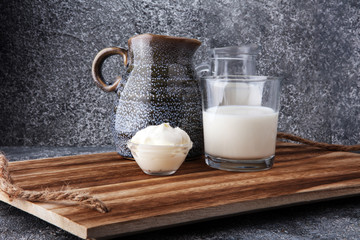 milk products - tasty healthy dairy products on a table sour cream in a bowl, cream and milk jar