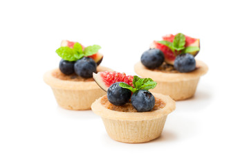 egg  custard tarts with fig slices and blueberry isolated on white