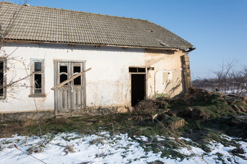 Old house made of clay against the background of the winter sky. Eco house.