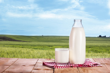 Bottle of fresh milk and glass is wooden table