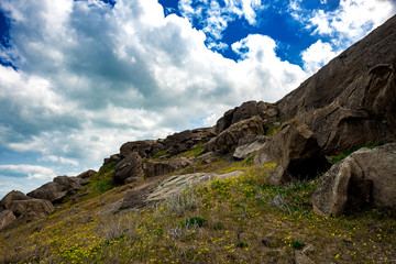Fototapeta premium Rocks fragments in the highlands, green meadow