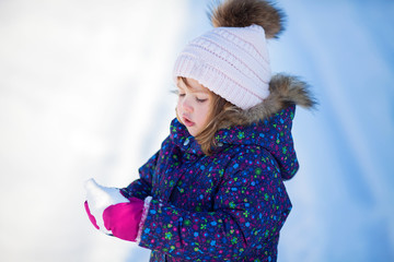 Little cute toddler girl outdoors on a sunny winter day.