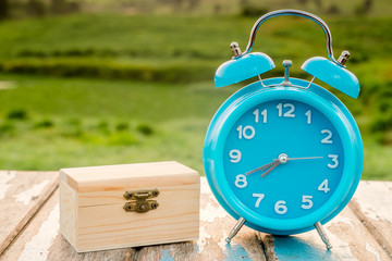 Motivation concept. Alarm clock and wooden box on wooden table