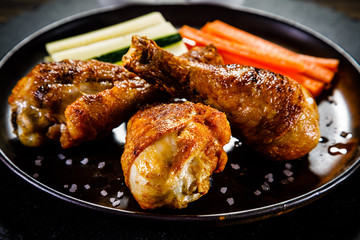 Roast chicken drumsticks on wooden background