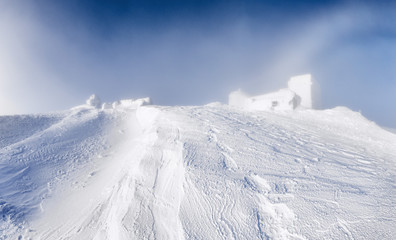 Fototapeta na wymiar Winter snowy mountain landscape. Tremendous construction snow capped , the old observatory in National Carpathian park in Ukraine.
