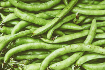 Organic natural imperfect vegetables with disabilities in a wicker basket on the market. Natural ecological green beans, legumes in the bazaar. Perfect background for a healthy organic food.