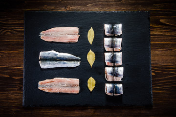 Raw herring on black stone