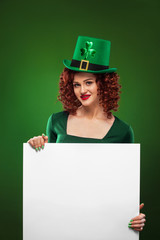St Patrick Day. Young sexy Oktoberfest waitress, wearing a dress and green hat with clover, serving big beer mugs on green background with banner for copy space