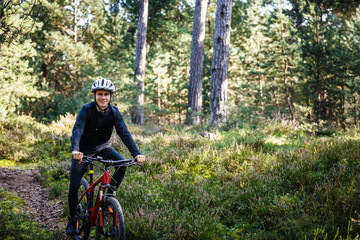 Young man biking in forest