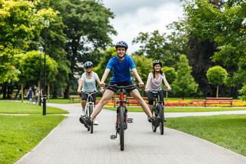 Healthy lifestyle - people riding bicycles in city park
