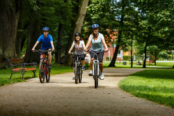 Naklejka premium Healthy lifestyle - people riding bicycles in city park