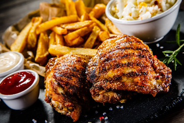Grilled chicken legs with French fries and vegetables