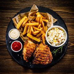 Grilled chicken legs with French fries and vegetables